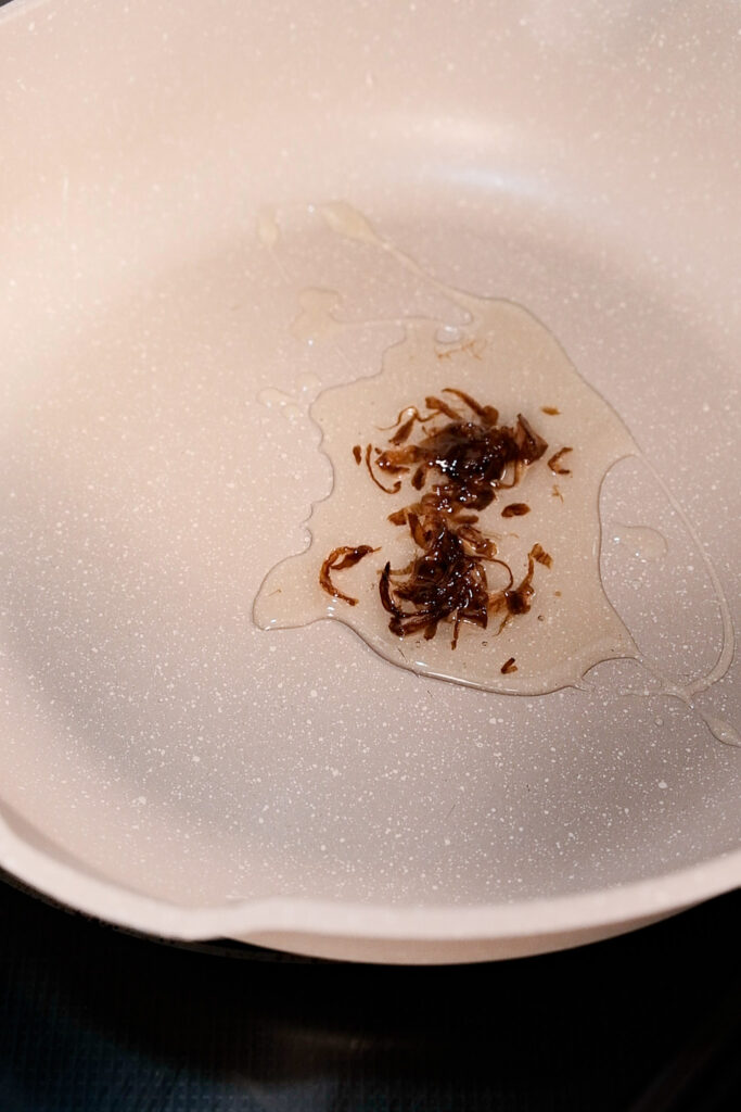 Putting onion infused oil into pan