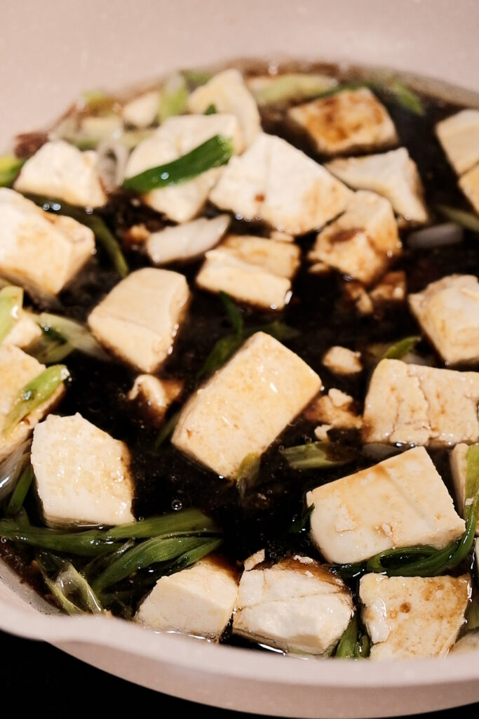 Adding the sauce to the tofu