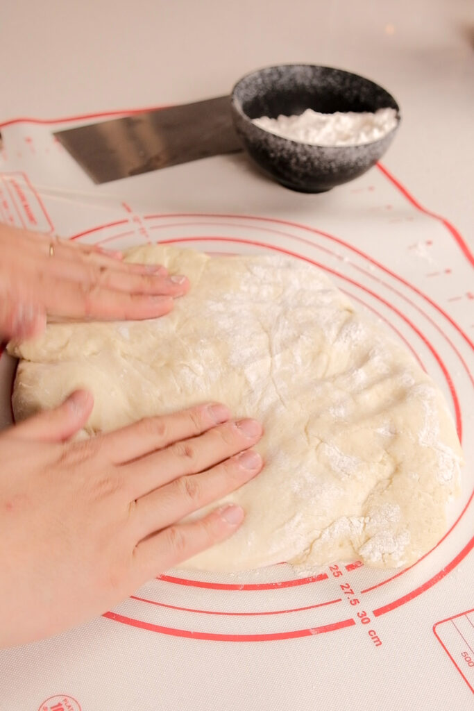 Flattening the dough to let out air
