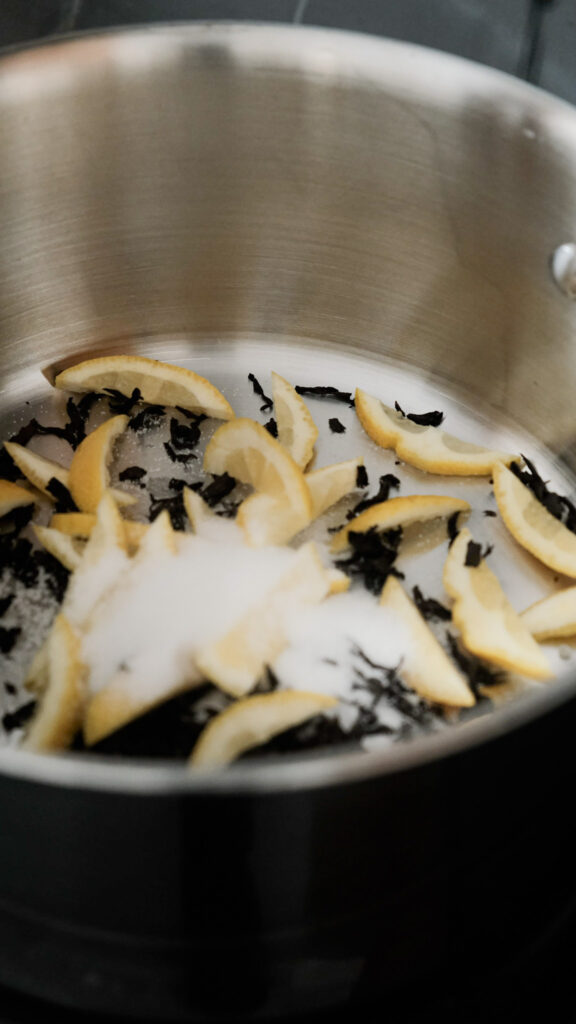 Adding sugar, lemon ends and tea into the pot
