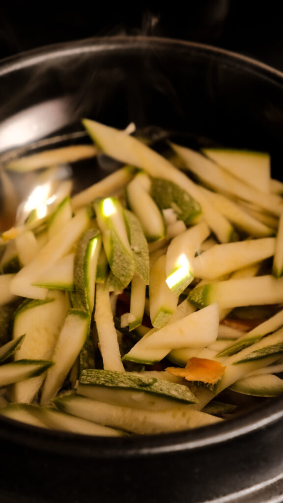 adding zucchini into sujebi soup