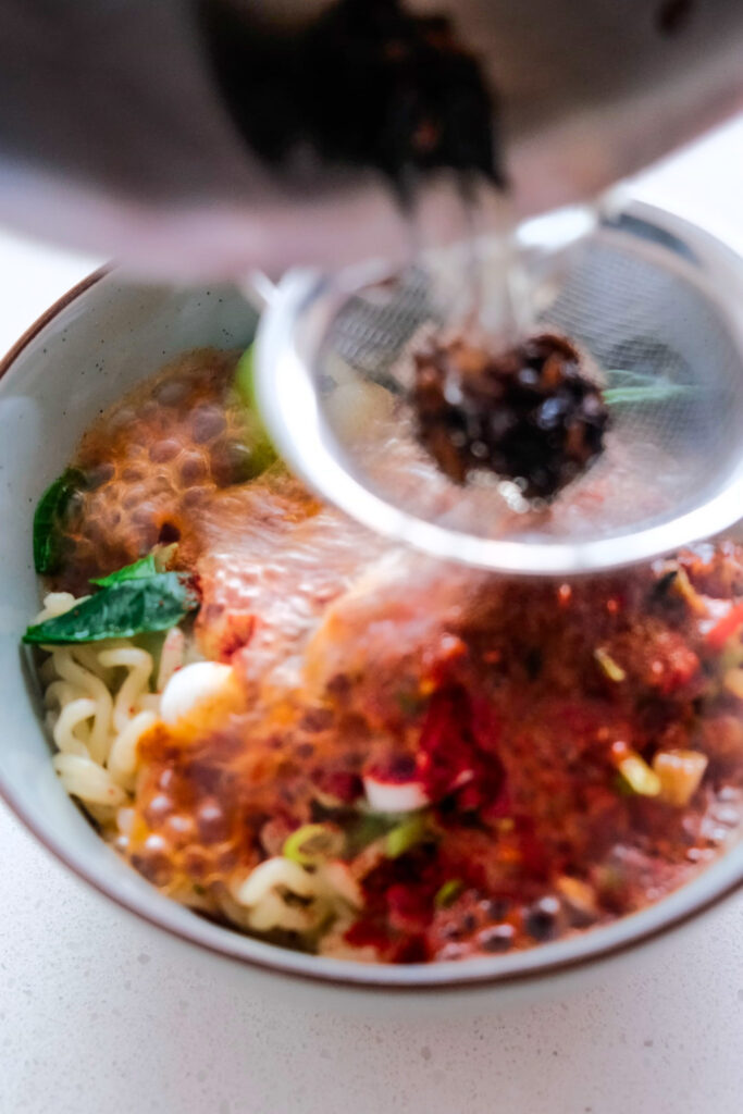 Pouring hot oil onto noodles