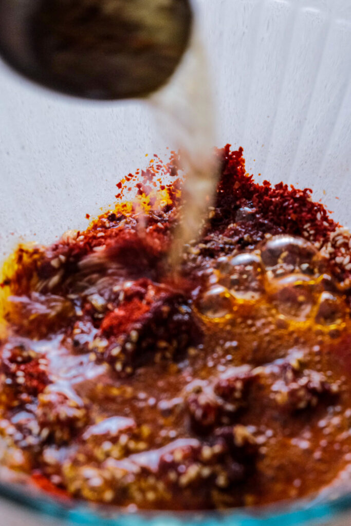 Pouring a bit of oil into chili flakes