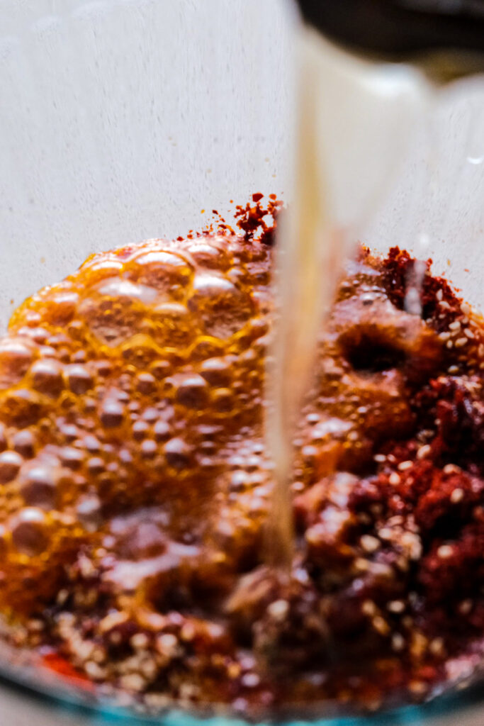 Pouring the rest of the oil into the chili flakes