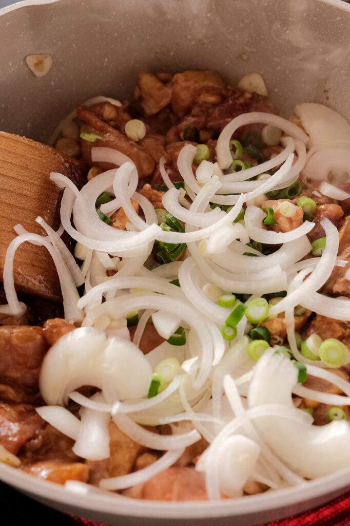 stir frying the chicken with scallions and onions