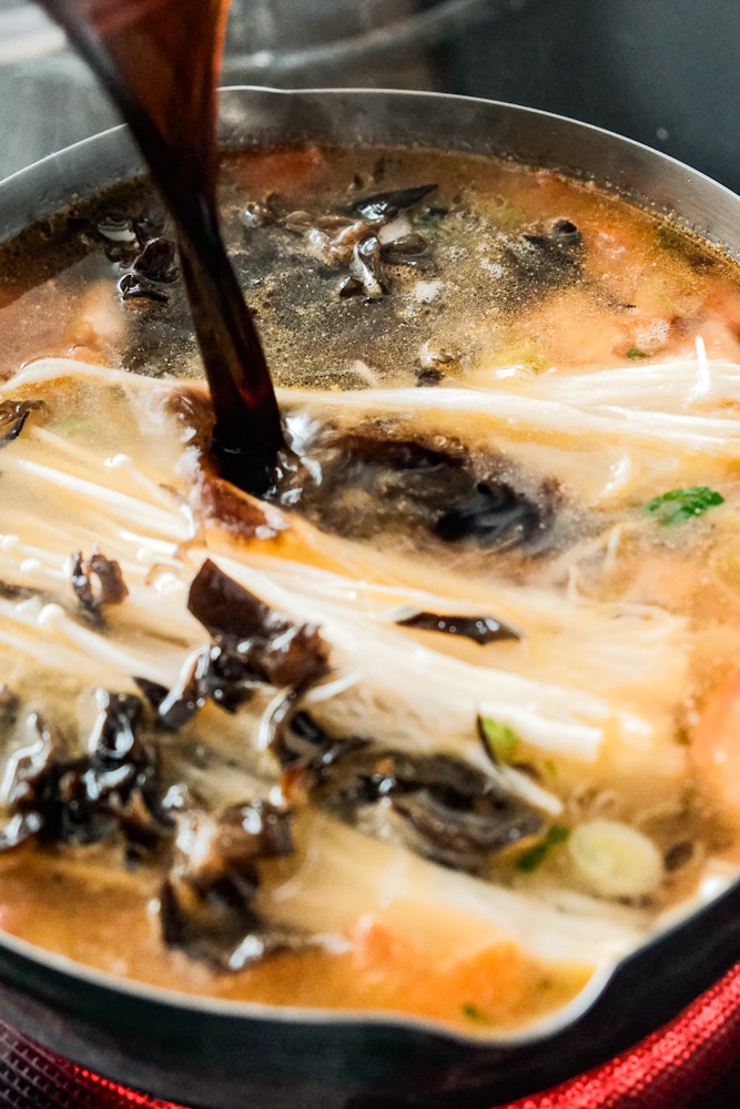 Adding vinegar into the soup